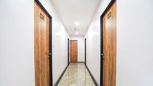 A hallway with wooden doors marked 403 and 406, leading to a room. - Fabhotel Prime Palace View (Vadodara)