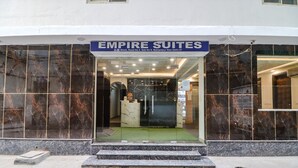 The exterior of Empire Suites hotel with a marble facade, a glass entrance, and a signboard above the door. - Fabhotel Empire Suites (New Delhi)