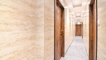 A hallway with marble walls and wooden doors, leading to a room labeled "BLUE".