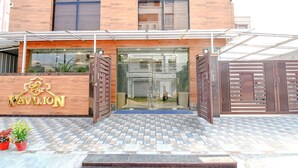 Un edificio moderno con fachada de madera, un cartel grande que dice "Pavilion" y una entrada con portones.