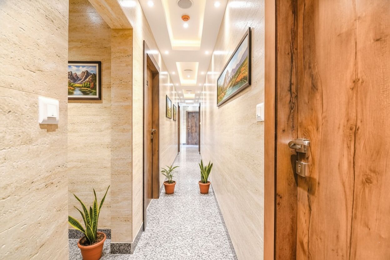 A hallway with a marble floor, wooden doors, and potted plants.