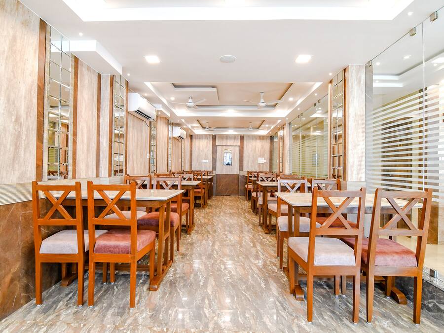 Ein geräumiges Restaurant mit Holztischen und -stühlen, einem Marmorboden und einem modernen Deckenstil.