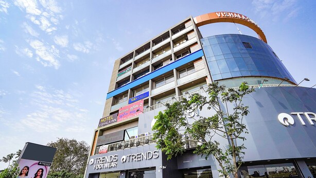 A multi-story building with a sign for 'Vishala Inn' and 'Trends Footwear' on the ground floor. - Fabhotel Vishala Inn (Ahmedabad)