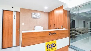 A hotel reception desk with a wooden finish, a reception sign, and a sign indicating room number 501. - Fabhotel Vishala Inn (Ahmedabad)