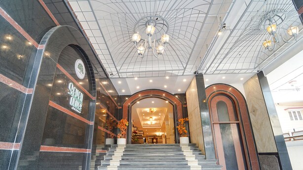 A grand entrance with a marble staircase, a chandelier, and a reception area. - Fabhotel Seven Olives (Bengaluru)