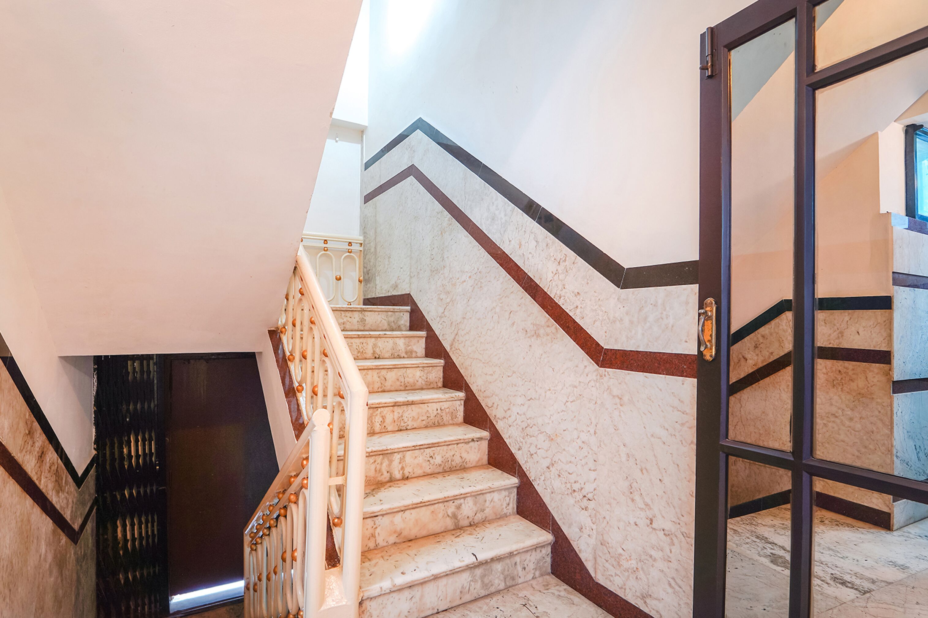 A staircase with marble steps and a black metal railing.