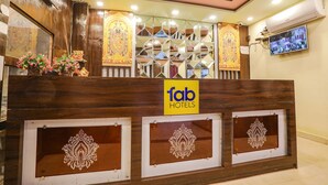 A reception desk with a 'fab hotels' sign, decorative mirrors, and a security camera. - Fabhotel Bala Ji Inn (Varanasi)