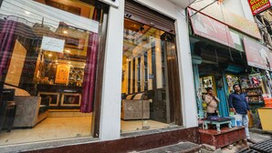 A hotel with a visible signboard, a glass entrance, and a small outdoor seating area. - Fabhotel Bala Ji Inn (Varanasi)
