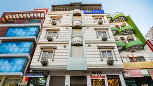 A multi-story building with a medical store on the ground floor, a hotel named "BalaJi Inn" on the second floor, and a Coca-Cola advertisement on the right. - Fabhotel Bala Ji Inn (Varanasi)