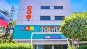 Un bâtiment moderne, orné d’une enseigne indiquant « fab hotels » et doté d’une façade colorée.
