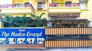The exterior of The Hudco Grand Hotel with a blue signboard displaying multiple room views. - FabHotel The Hudco Grand (Patna)