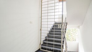 A staircase with metal railings leading to a balcony. - FabHotel Blue Dawn Suites (Hyderabad)