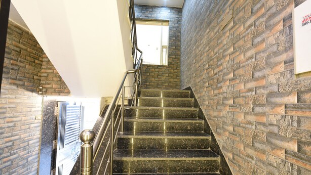 Eine Treppe mit Metallgeländer und einer Backsteinmauer an der Seite.