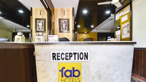 A reception desk with a sign reading "RECEPTION" and "fab hotels" logo. - Fabhotel Sanjay Palace (Jaipur)