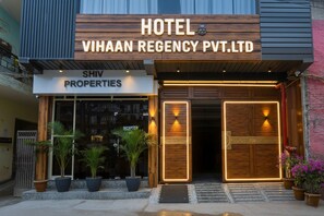 A hotel entrance with a wooden facade, a reception area, and potted plants. - FabHotel Vihaan Regency (New Delhi)