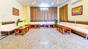 A hotel lobby with a seating area, ceiling fans, and an air conditioning unit. - Fabhotel Golden Manor Inn (Jaipur)