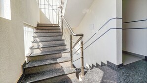A staircase with metal railings and stone steps, leading to a higher floor. - Fabhotel Emirates Inn (Bengaluru)