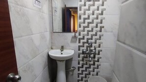 Un baño con lavamanos, espejo y paredes con azulejos.