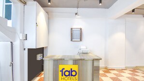 Una recepció amb un cartell de 'fab hotels', un quadre al mur i un mostrador d'entrada.