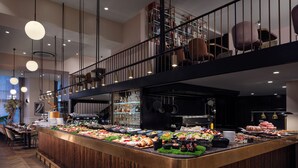 A buffet with a variety of food items, a kitchen area, and a seating area with chairs and tables.