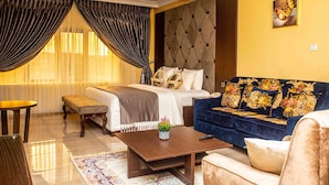 Una habitación de hotel con una cama, un sofá, una mesa de centro y una mesita.