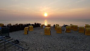 A beach with yellow sand and a sunset in the background. - Kleine Düne (Cuxhaven)