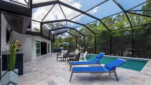 An outdoor pool area with lounge chairs and a covered seating area. - Rustic Sands - 650   “Siesta Key” (Sarasota)