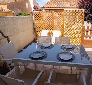 Enjoy meals al fresco at this outdoor dining area, complete with a table for four and comfortable seating.