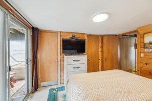 Une chambre à coucher avec un lit, une télévision et des armoires en bois.