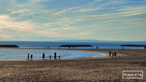 A beach with people walking and standing, a clear sky, and distant mountains. - Riboleys - Villa avec clim et piscine privée (Vias)