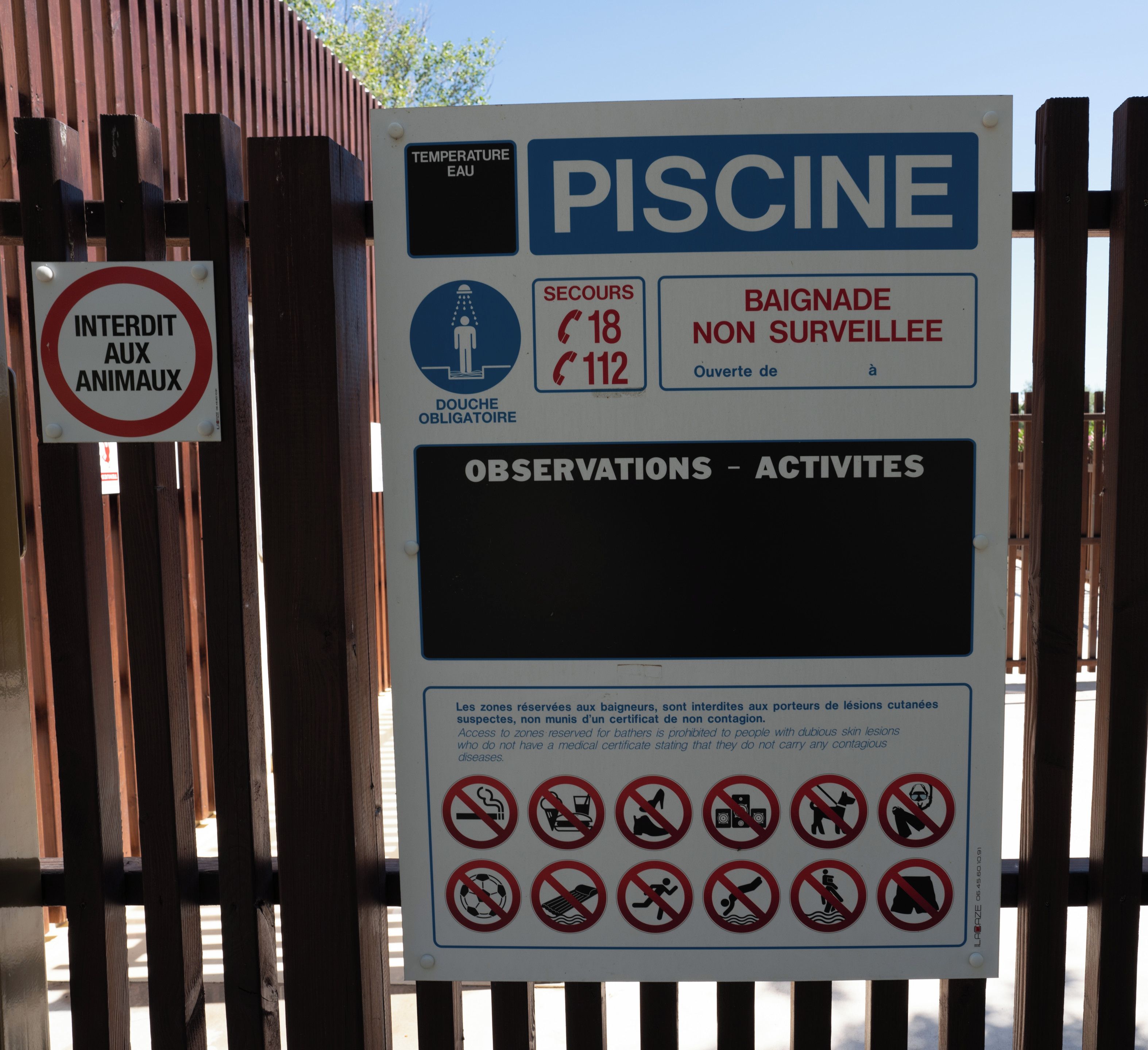 A sign with multiple sections including a swimming pool, a no animal sign, and various prohibitions.