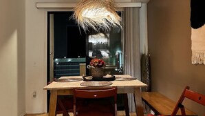 Ein Essbereich mit einem Holztisch, gewebten Tischsets und einer hängenden Leuchte.