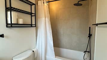 Bathtub, hair dryer, towels, toilet paper