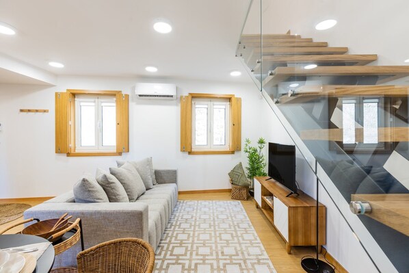 A modern living room with a sofa, a dining table, and a staircase. - Inner Center Porto (Porto)