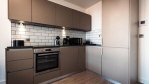 Una cocina moderna con electrodomésticos integrados, microondas y cafetera.