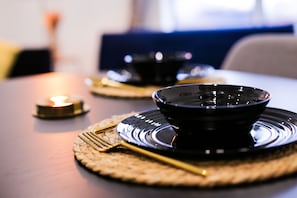 A table with a black bowl and a candle, set on a woven placemat. - Cozy Luxury City Apartment in Central Bracknell (Bracknell)