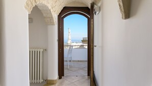A corridor with a view of a statue and a building in the distance.