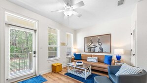 A living room with a sofa, coffee table, and a painting on the wall. - A Tranquil Retreat Amidst 30A's Glorious Beaches (Santa Rosa Beach)