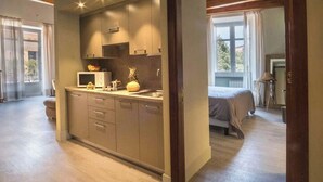 Ett modernt kök med en central köksö, inbyggda skåp och ett fönster med utsikt över en trädgård.