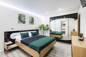 Quarto moderno com uma cama grande, mesas de cabeceira, um espelho e obras de arte na parede.