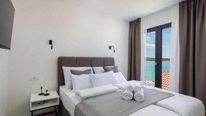 A hotel room with a bed, a nightstand, and a view of the sea. - Villa Dragica - Private villa with pool, Sibenik (Zaboric)