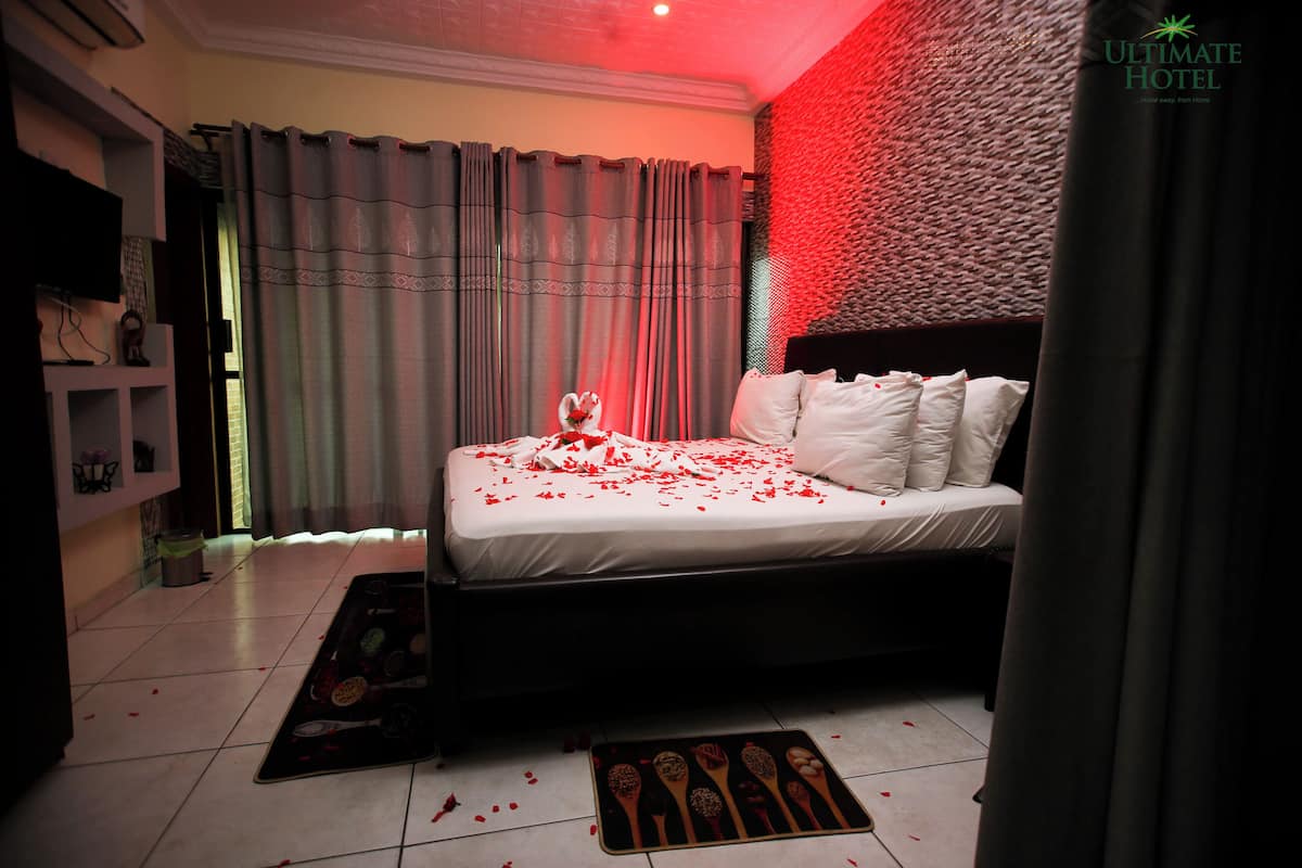 Una habitación de hotel con cama, cortinas y un detalle decorativo en la pared.