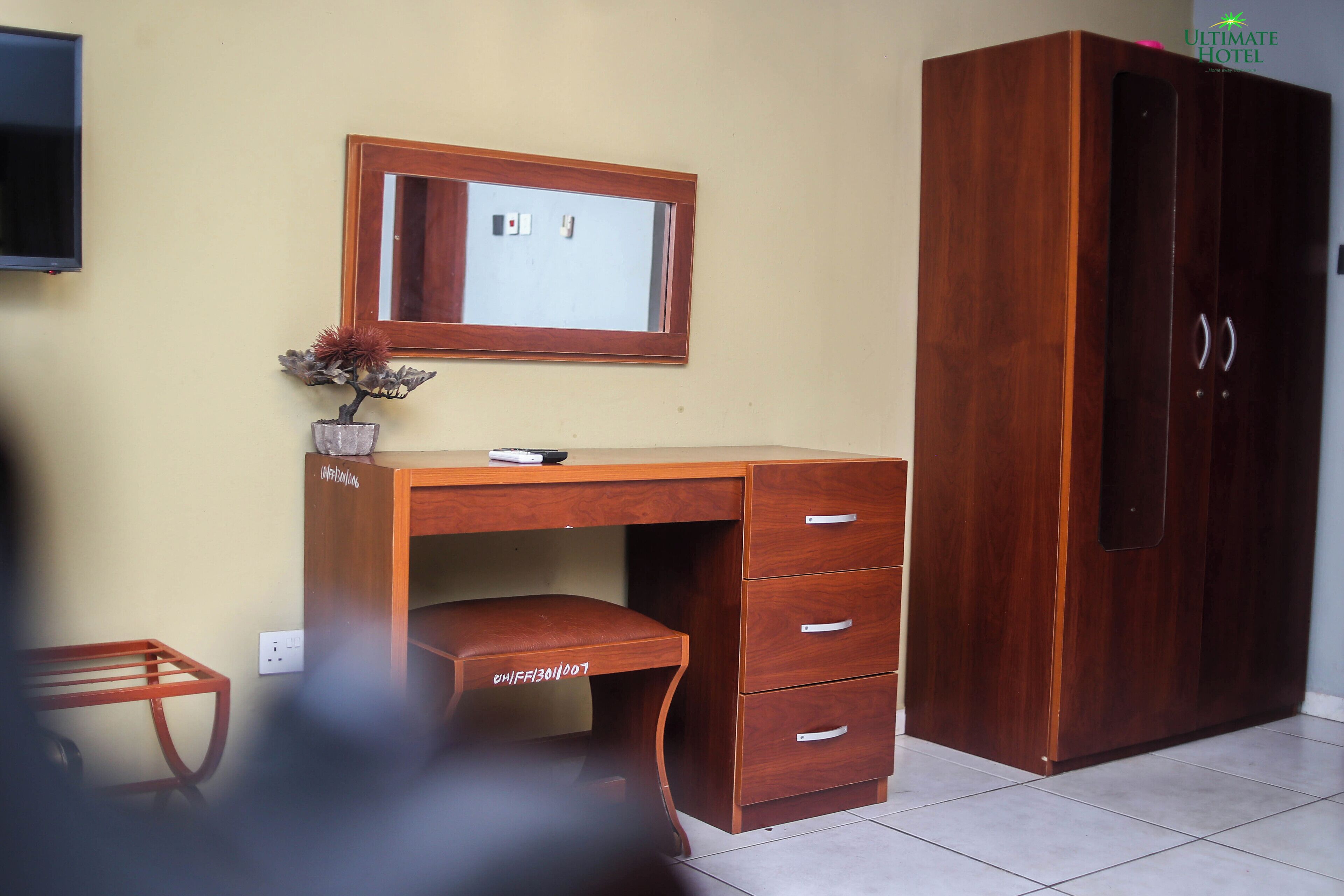 A wooden desk with a mirror, drawers, and a small plant.