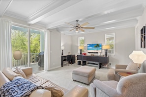 A spacious living room with a large TV, comfortable seating, and a balcony with a view. - Aqua Bay 3BR by RVA-Poolside Luxury, Pets Too (Longboat Key)