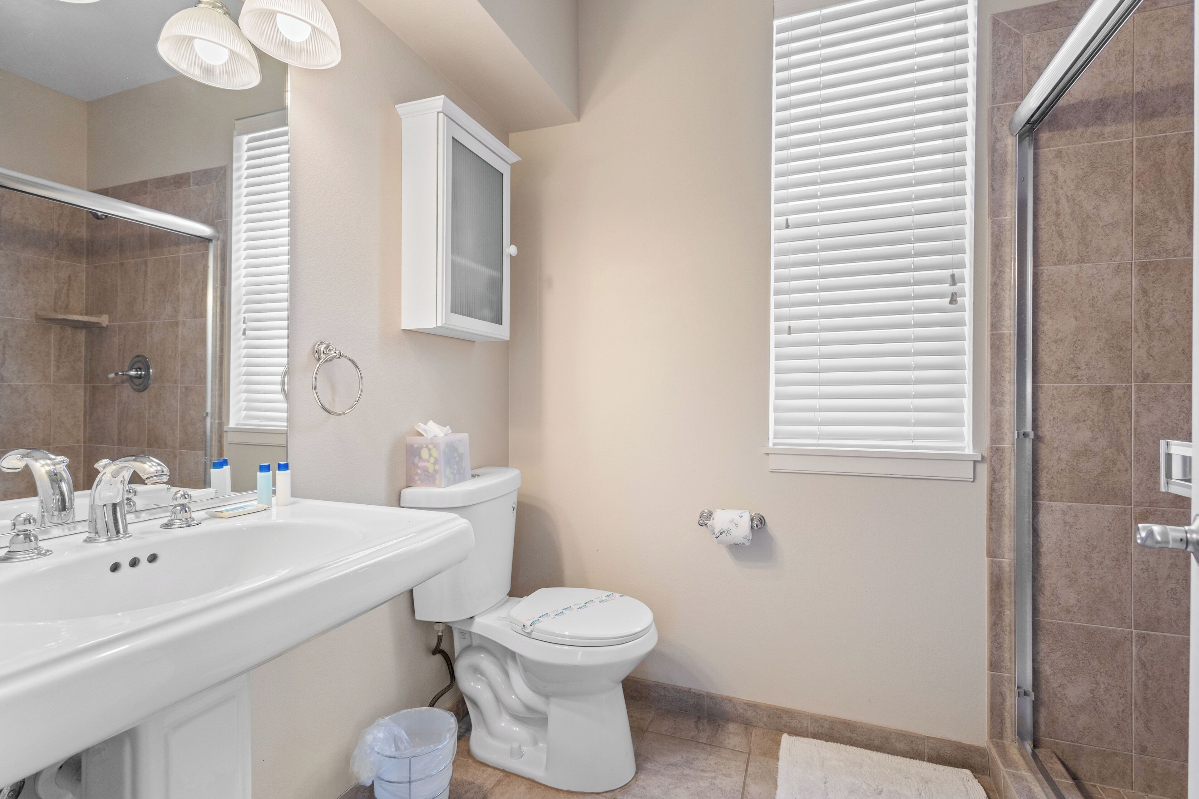 Une salle de bain avec un lavabo, des toilettes et une douche.