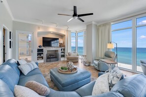 A spacious living room with a fireplace, a large TV, and a view of the ocean. - Beautiful end 3 bdr unit with fabulous views, Spring/Summer open book now! (Panama CIty Beach)