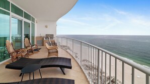 A balcony with wicker furniture, a grill, and a view of the ocean. - Turquoise Place 1807C by Liquid Life (Orange Beach)
