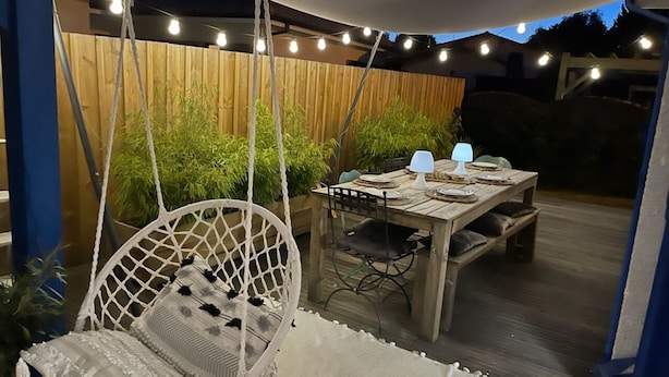 An outdoor dining area with a wooden table, chairs, and string lights. - Maison Entre LAC ET Ocean A Hourtin EN Gironde, Idéal Avec de Jeunes Enfants ! (Hourtin)