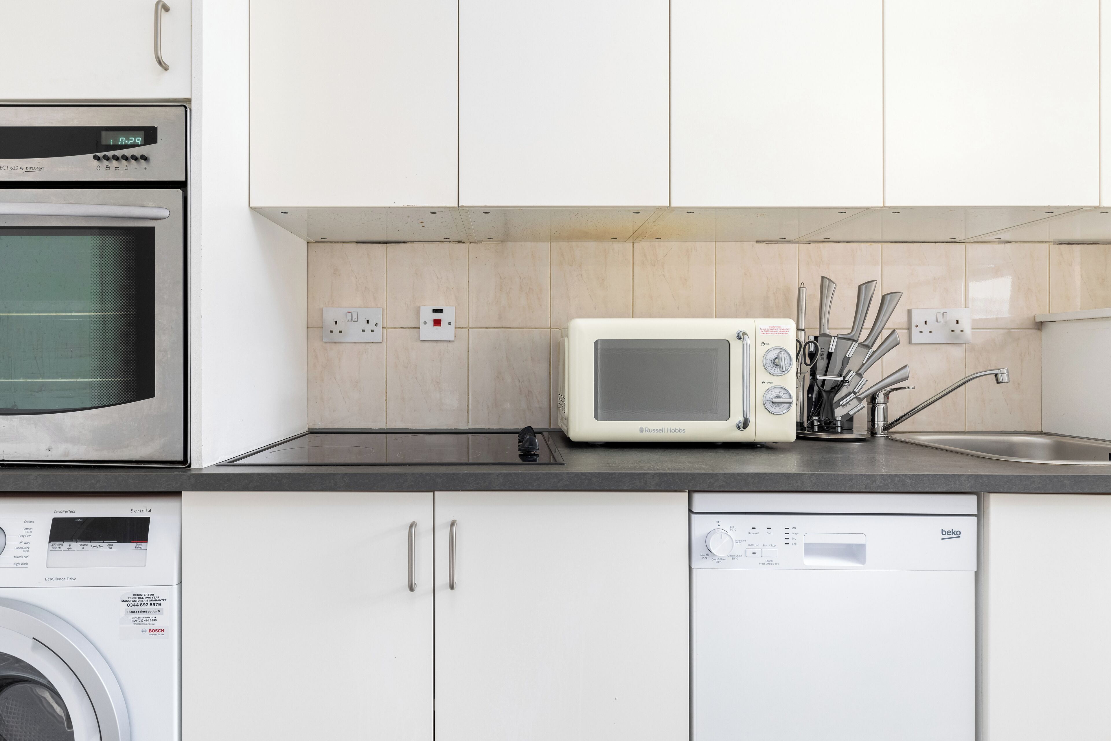 Eine Küche mit Mikrowelle, Backofen und Geschirrspüler.