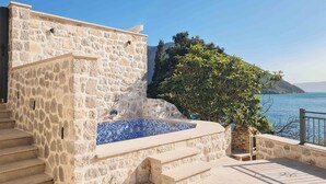 A stone building with a pool, steps leading to a terrace, and a view of the sea. - Step to Kotor Bay Perast (Perast)